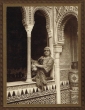 Dona photographiée dans son costume devant un décor andalous