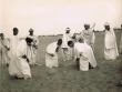 Hommes et enfants jouant sur le sable
